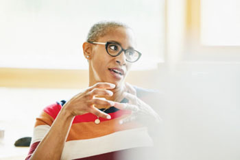 Woman gesturing with her hands to colleagues